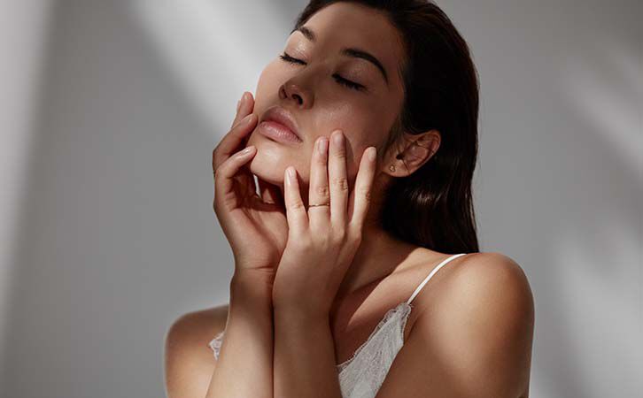 Woman practising a relaxing hand massagin soft natural light.